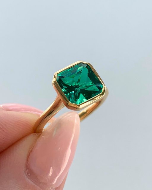 Gemstone engagement rings are on our radar for 2025. 

The Details: 18K Yellow Gold Luna Bezel Ring set with a 8mm Radiant Cut Lab Created Emerald Gemstone. 

Drop a 💚 if you would say yes to this ring.