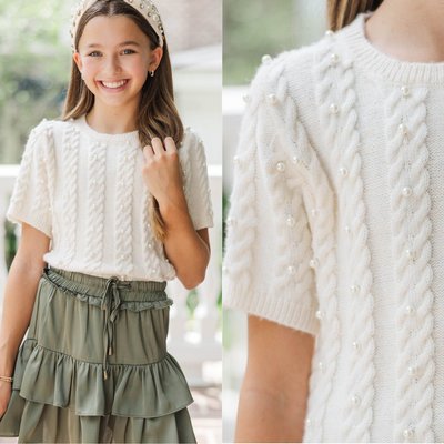 A cozy fall essential 🍂🤍✨ Soft cream knit with delicate pearl details makes it a must-have for crisp days, family photos, and every little moment she’ll treasure. Designed with a rounded crew neckline, ribbed short sleeves, and a classic cable knit pattern with pearl accents, this sweater offers a timeless look with moderate stretch for comfort and layering all season long. 🧡🎀🍁

$42 >> Girls: The Class Act Cream Pearl Knit Sweater