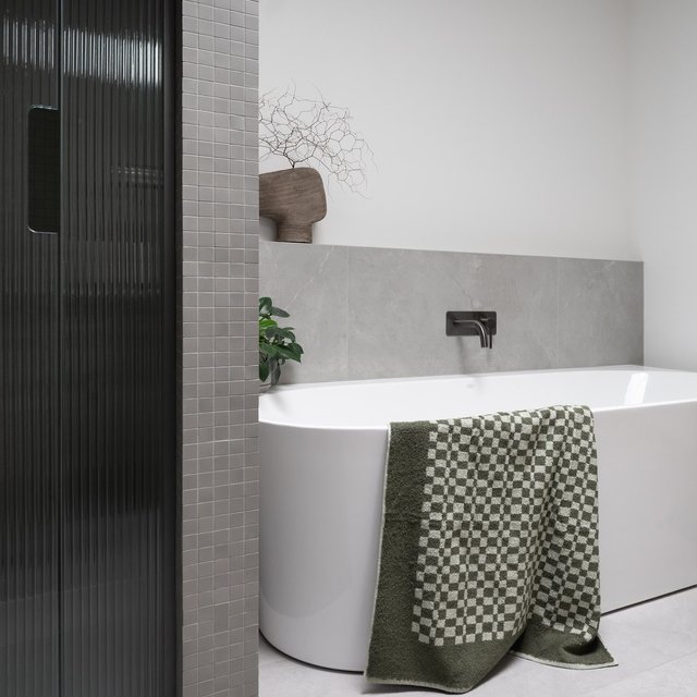 Family bathroom with sleek grey tiles and an eye-catching mosaic, this space is all about modern elegance. The reed glass shower door adds a touch of sophistication, while the skylight above fills the room with natural light ✨ 

📸 avenuemedia_ 

◻️

#turtonbuilders #hamiltonnz #waikatonz #newhome #newbuild #interiordesign #bathroom #bathroominspo #bathroominspiration #bathroomdesign #reededglass