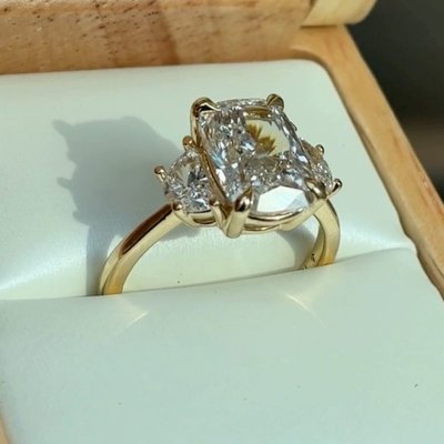 POV: you’re planning for your 2026 engagement. The details: 18K Yellow Gold Half Moon Three Stone Diamond Ring set with an Elongated Cushion Lab Diamond